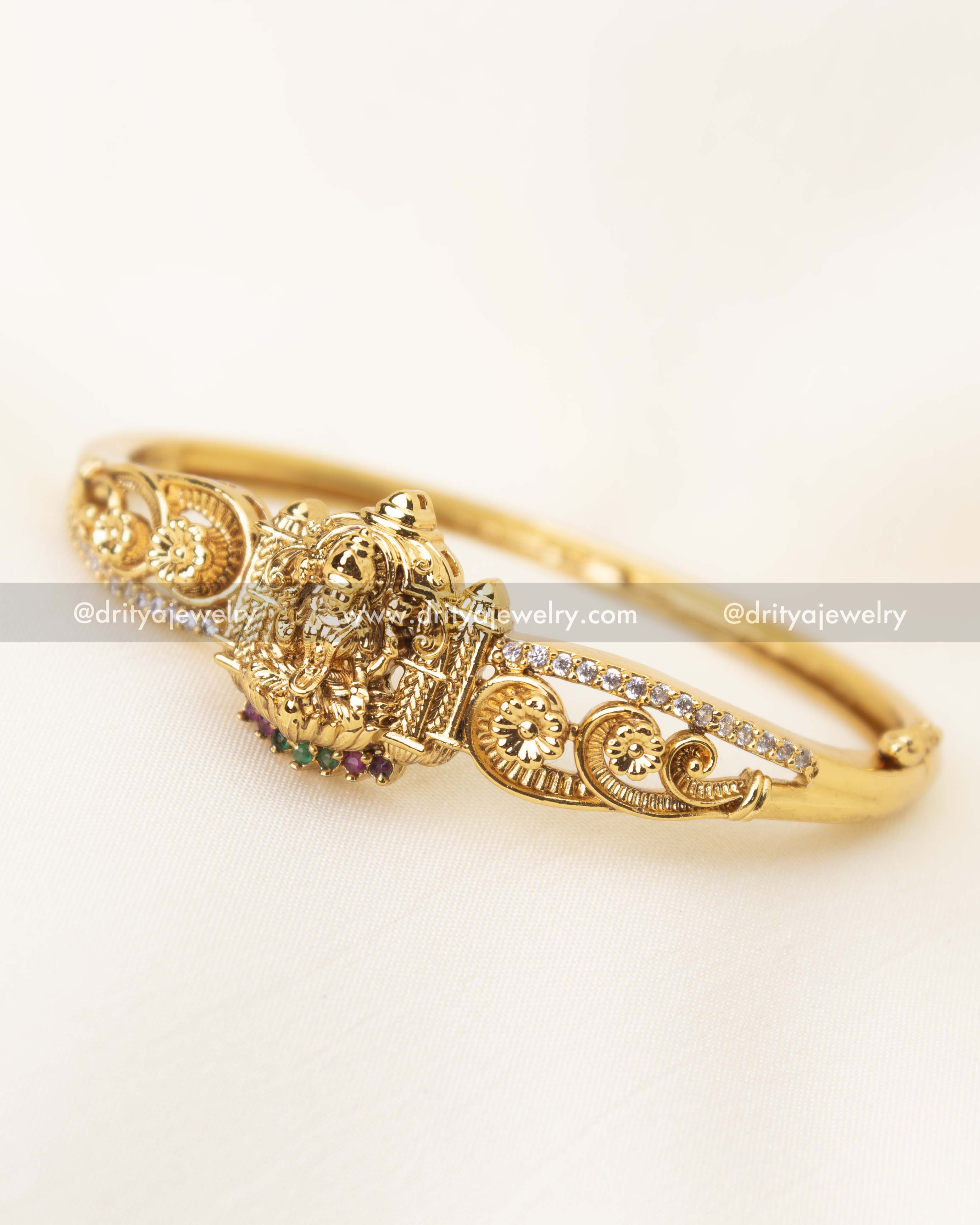 Close-up of Goddess Lakshmi Devi carving on temple kada with CZ accents and antique gold finish