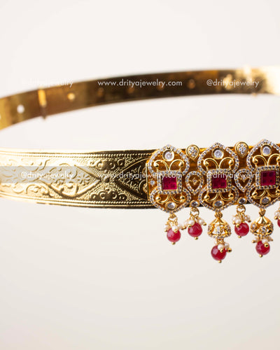 Detailed view of ruby bead and pearl hangings on traditional gold polish vaddanam