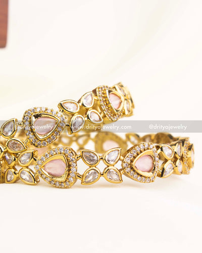 Victorian gold-plated bangles with blush pink AD stones and teardrop detailing by Dritya Jewelry.