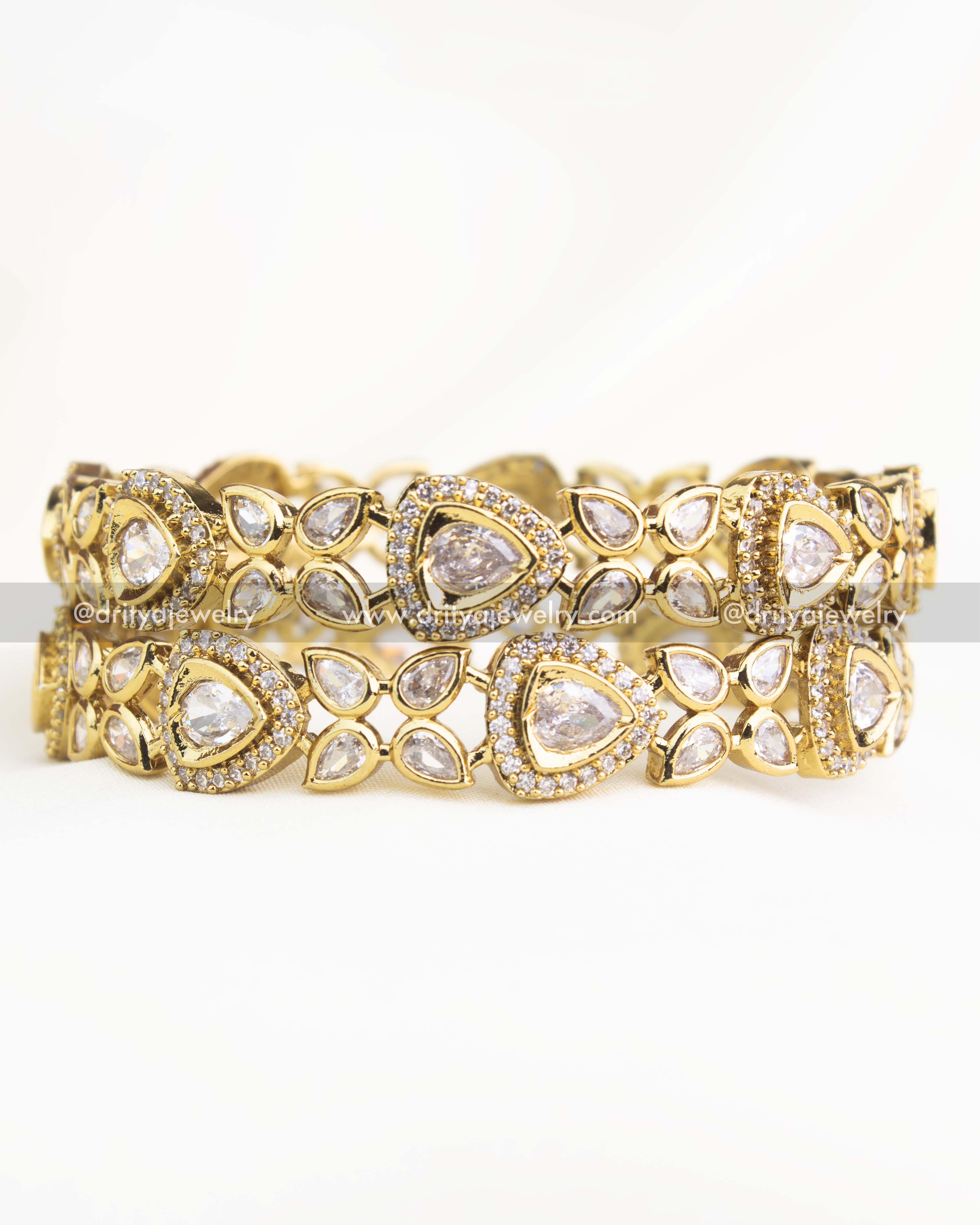 Close-up shot showing intricate AD stone detailing and Victorian gold finish of diamond-white bangles.