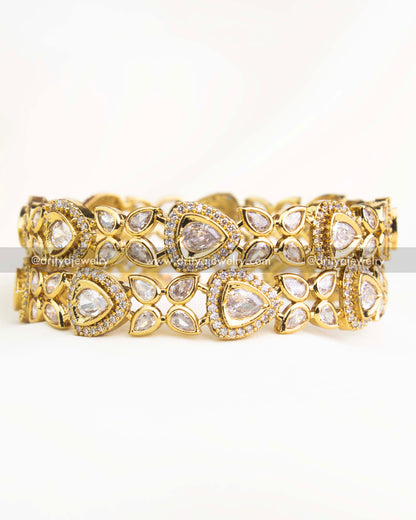 Close-up shot showing intricate AD stone detailing and Victorian gold finish of diamond-white bangles.
