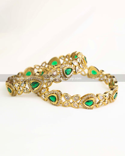Emerald green AD stone Victorian bangles with gold polish and teardrop motifs.