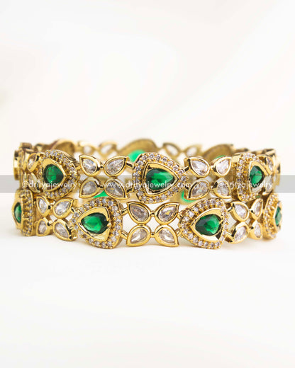 Emerald green AD stone Victorian bangles with gold polish and teardrop motifs.