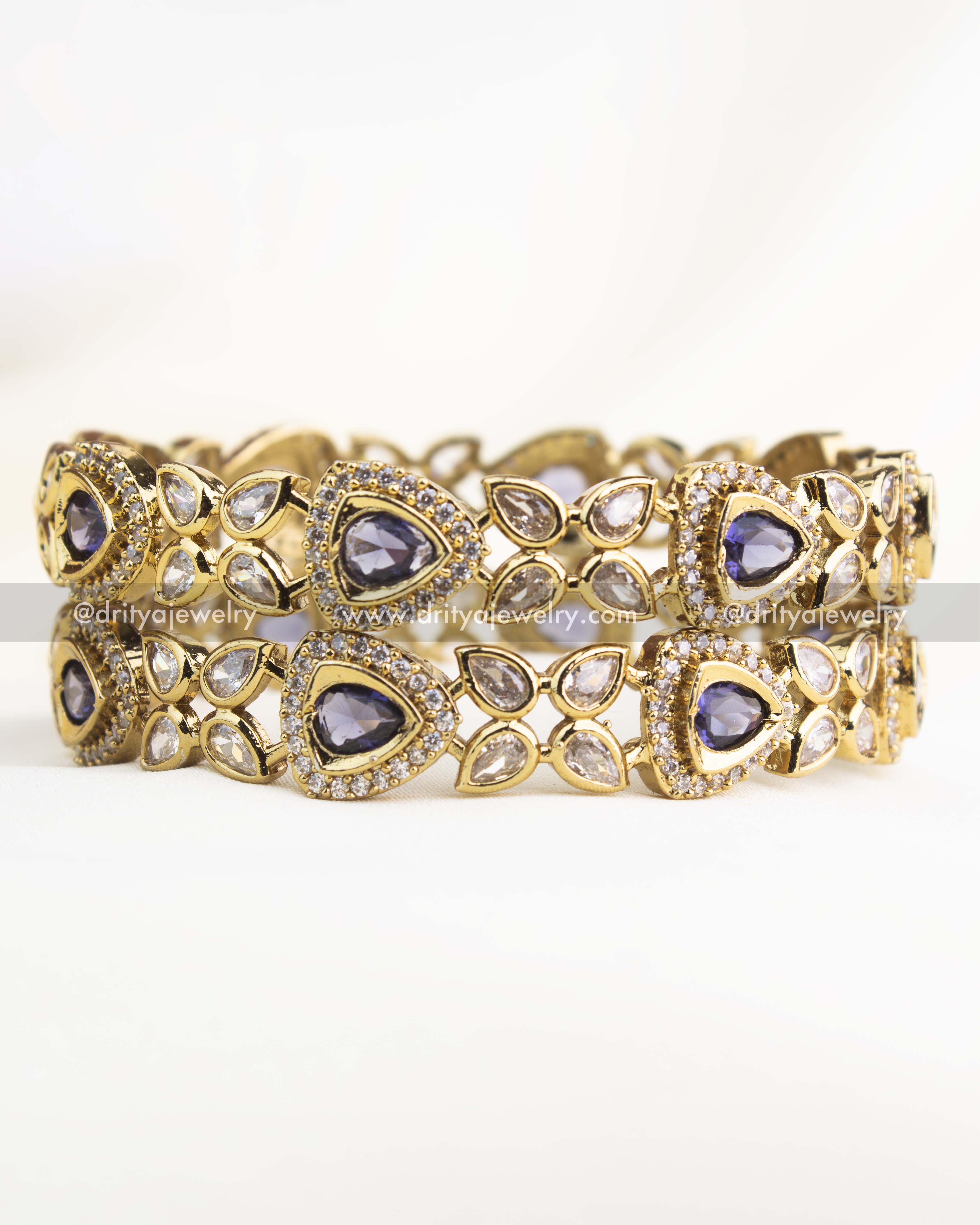 Elegant Victorian bangles with purple AD stones in teardrop design and antique gold finish.