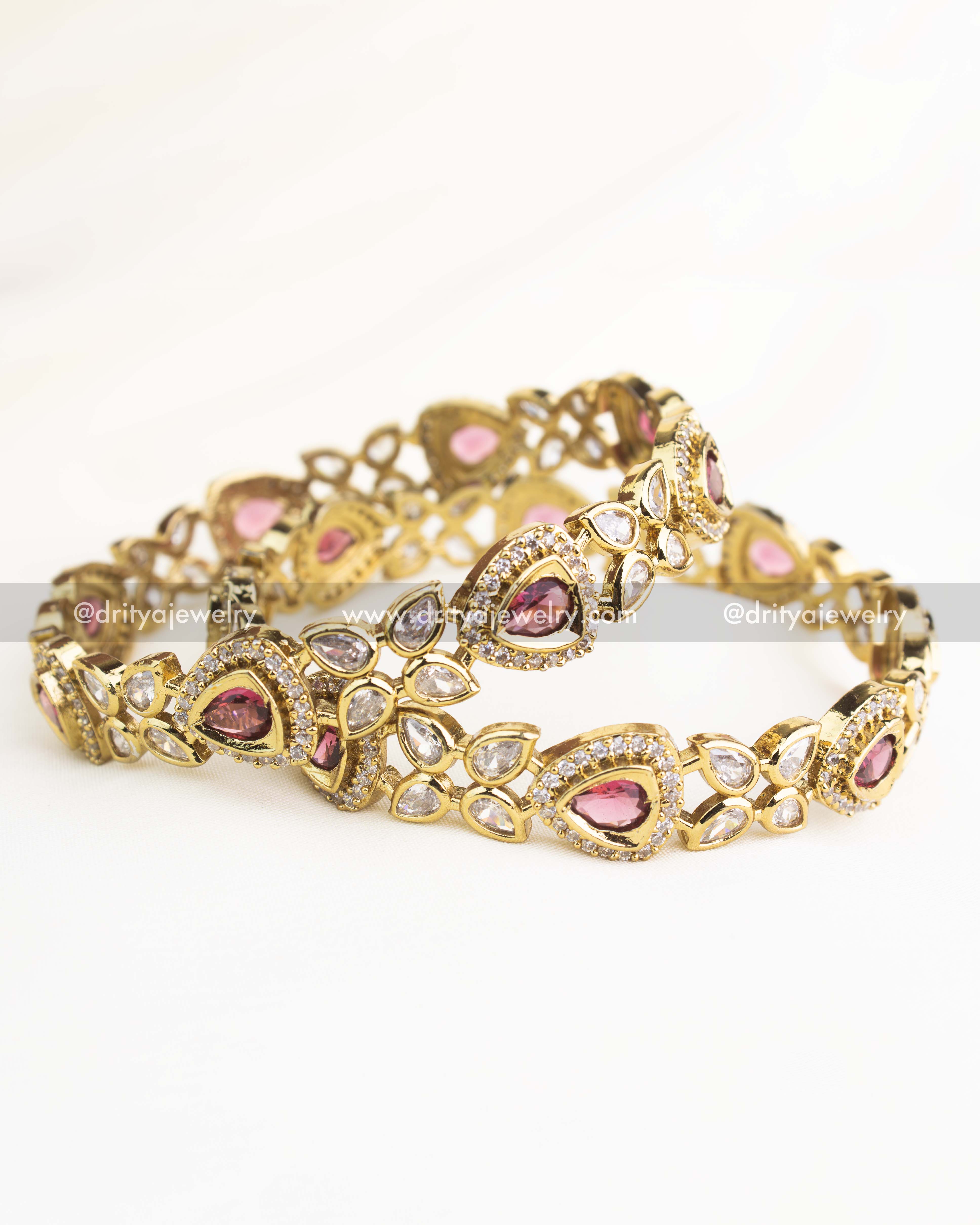 Victorian-style bangles with ruby red teardrop stones and white AD detailing in gold-plated finish.