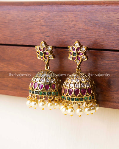 Intricate dome jhumka earrings with Victorian polish, floral top, and hanging pearls.