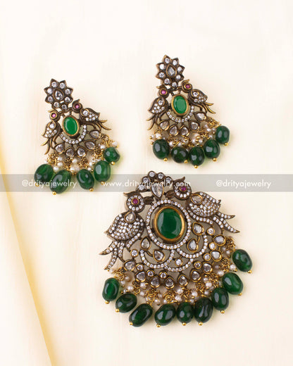 Antique gold-plated Victorian pendant set with green centerpiece and peacock detailing.
