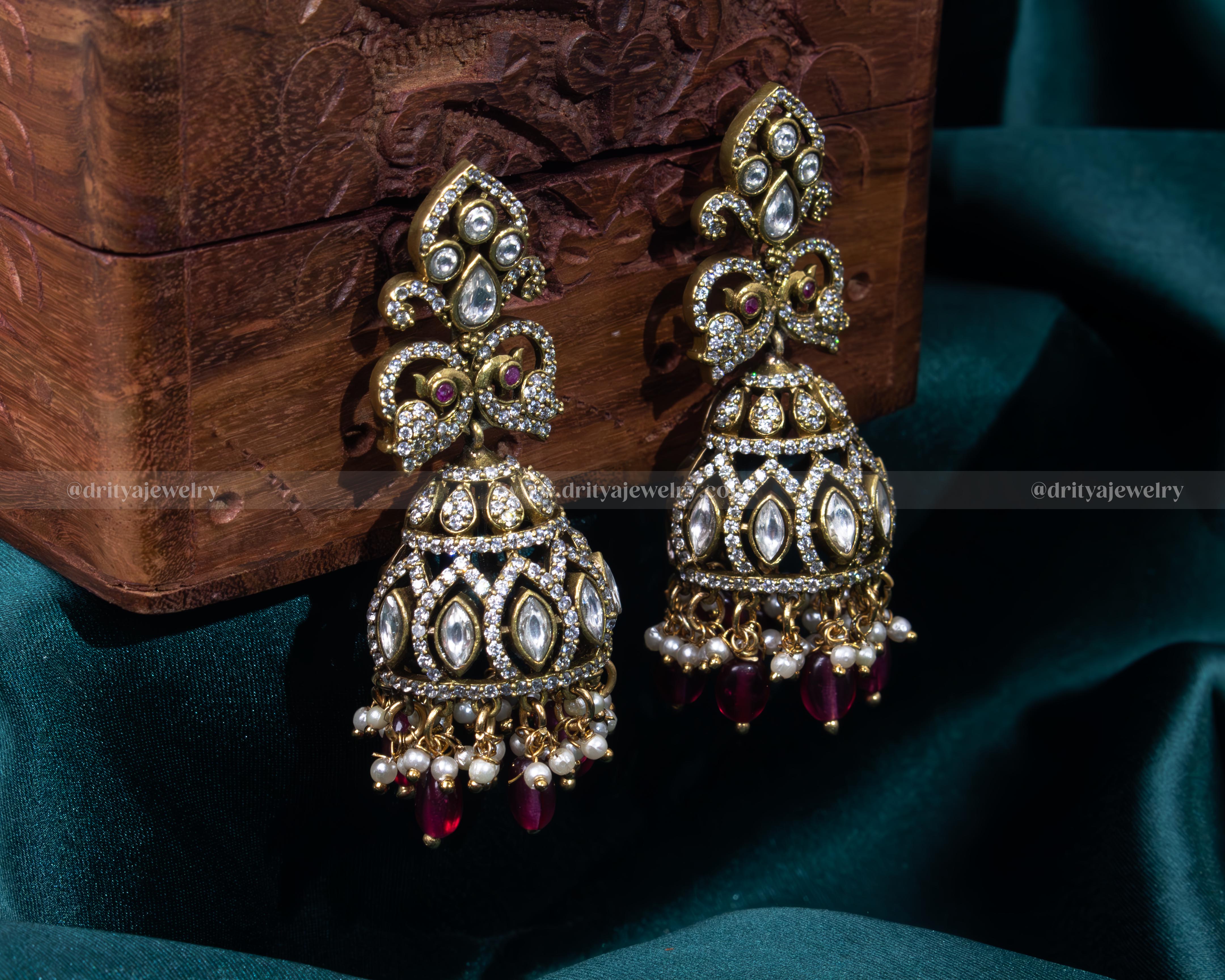 Elegant gold-plated Victorian jhumka earrings with faux ruby and pearl details, ideal for traditional events and formal gatherings.