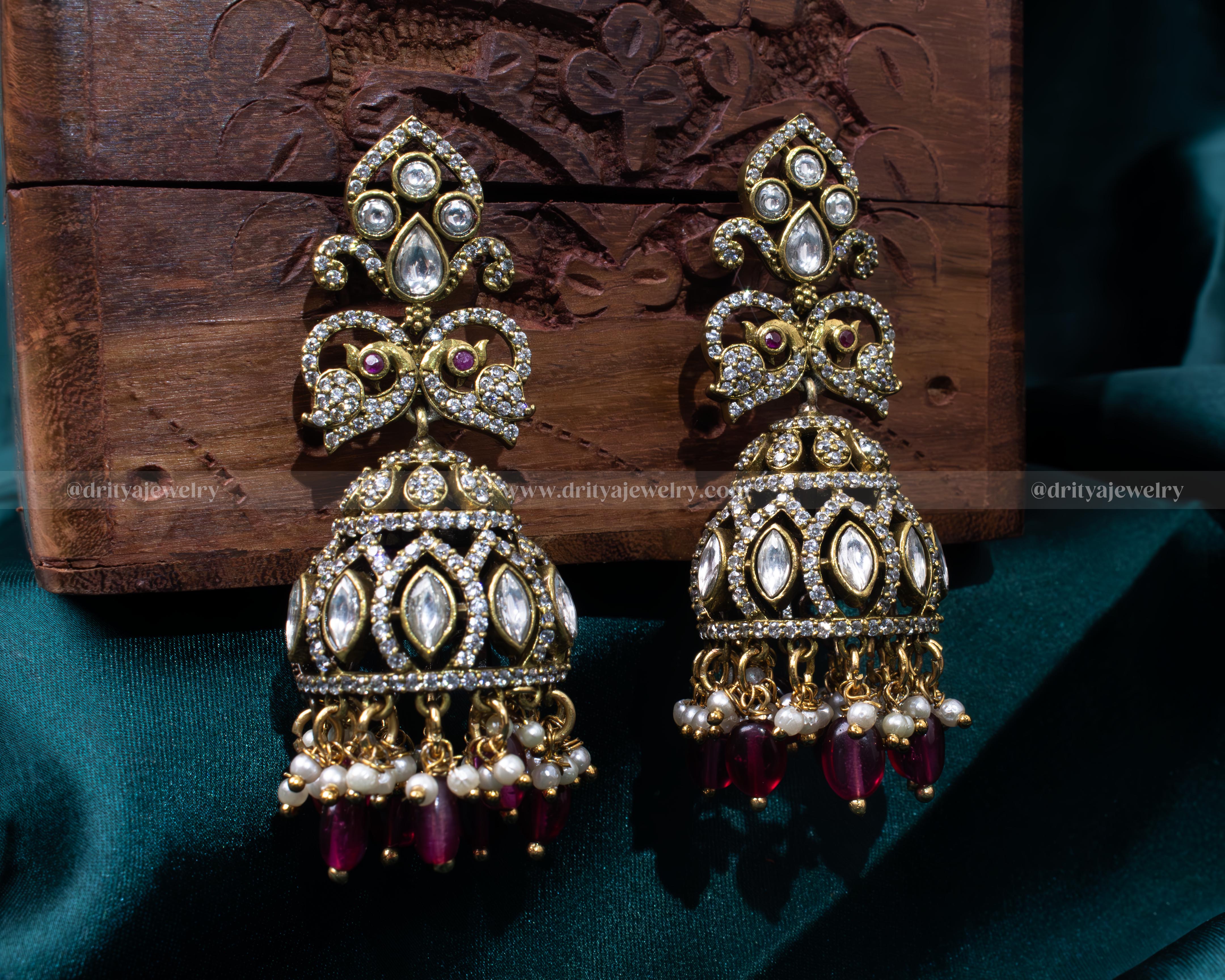 Elegant gold-plated Victorian jhumka earrings with faux ruby and pearl details, ideal for traditional events and formal gatherings.