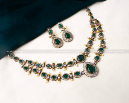 Premium Victorian layered short necklace with emerald-colored stones, zircon detailing, and pearl embellishments, paired with statement earrings.