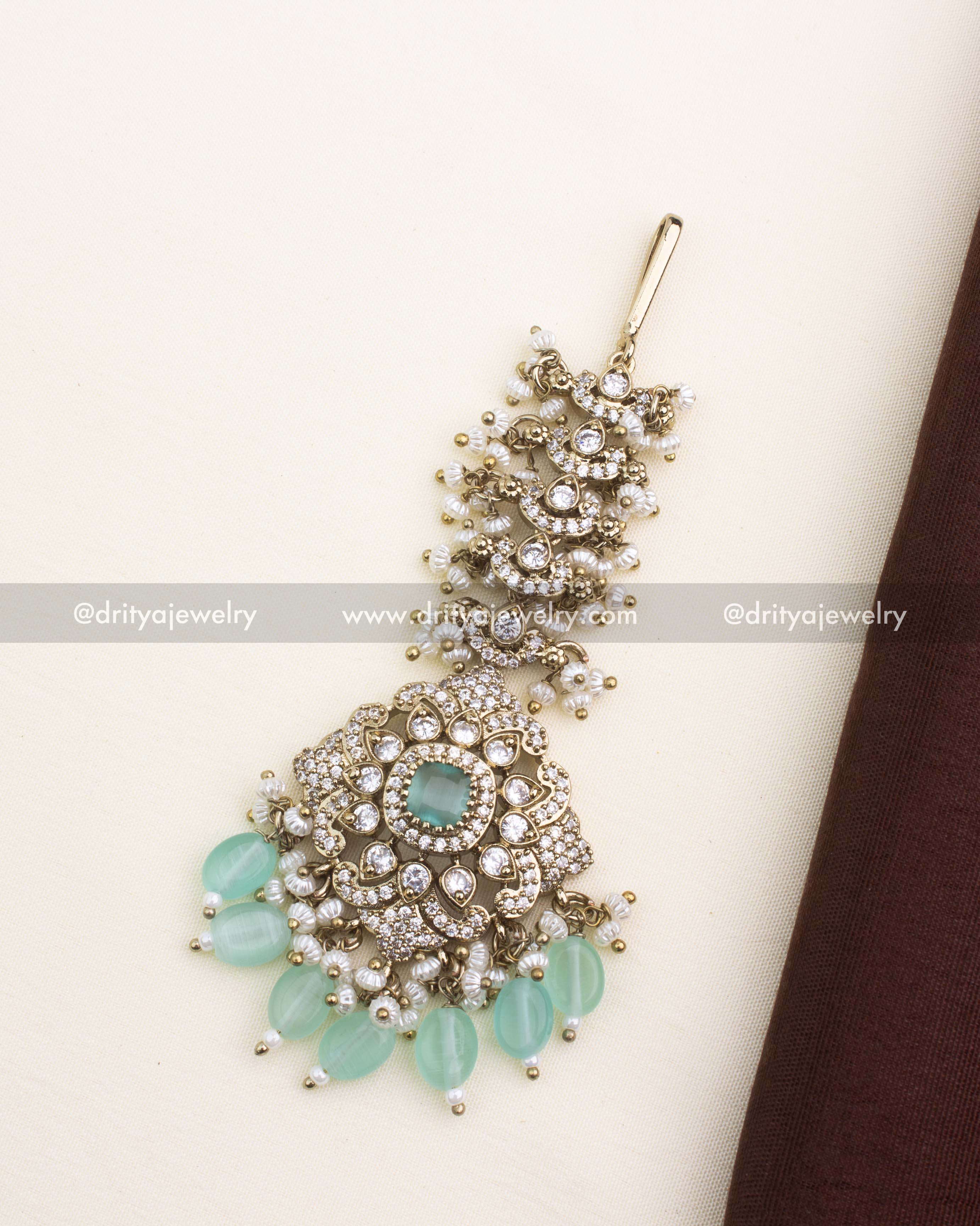 Antique gold Victorian maang tikka with mint green stones, CZ work, and pearl detailing.