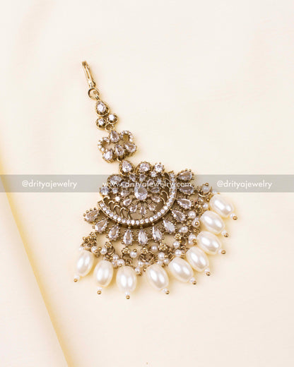 White-stone Victorian-style maang tikka with pearl drops in antique gold finish.