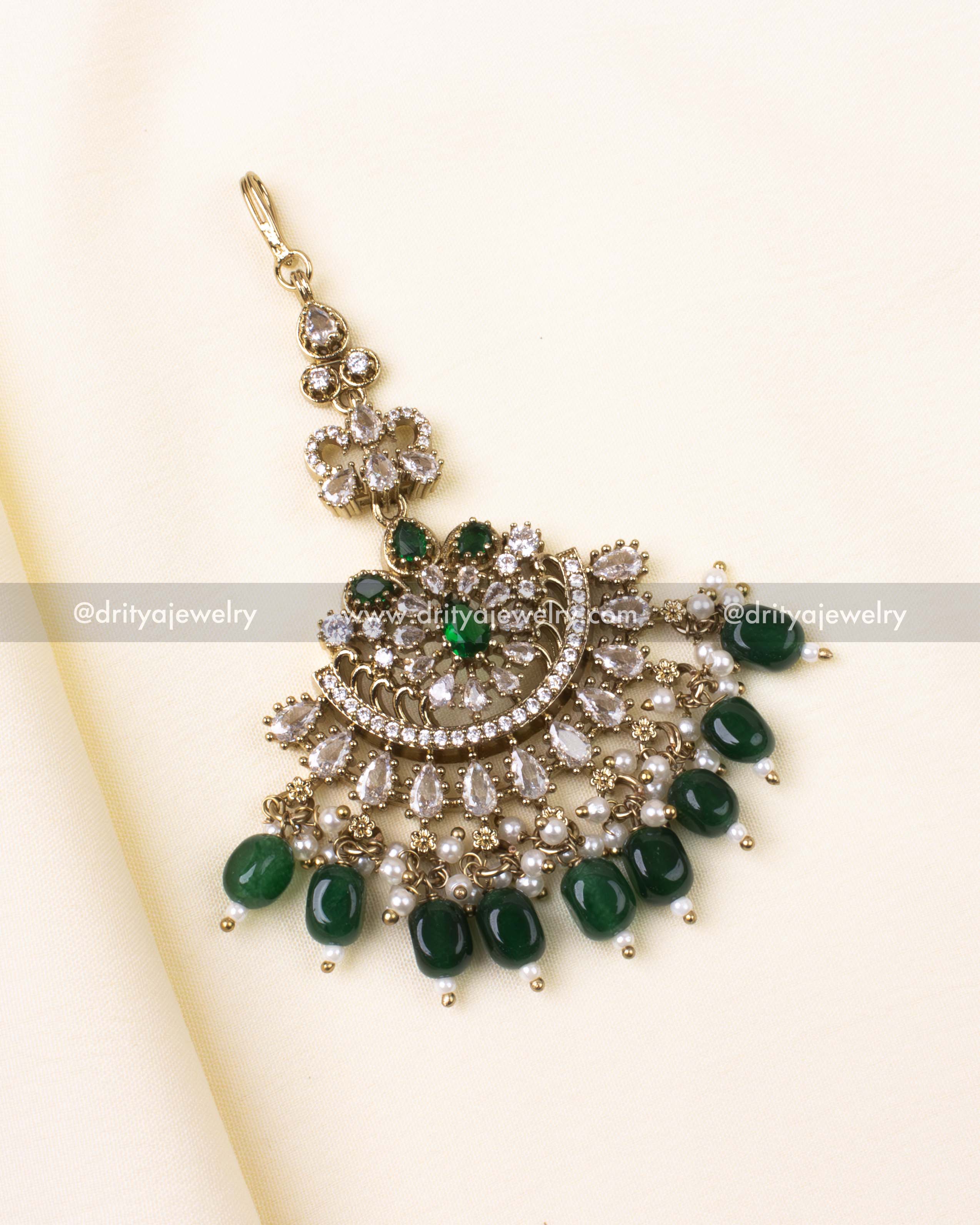 Green and gold Victorian-style maang tikka with pearls and AD detailing.