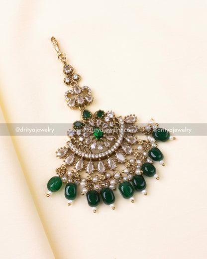 Green and gold Victorian-style maang tikka with pearls and AD detailing.