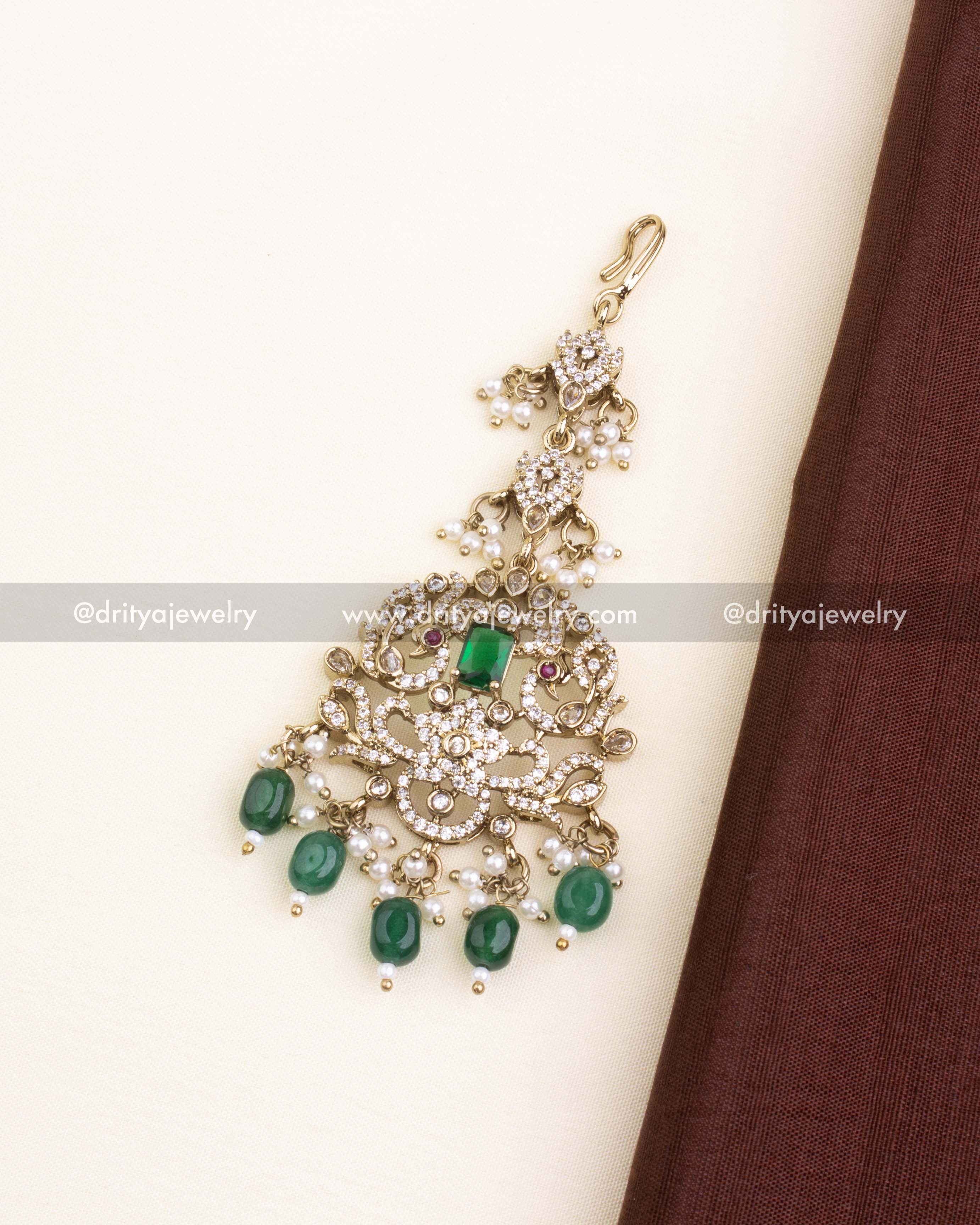 Gold-toned Victorian maang tikka with green centerpiece and bead danglers.
