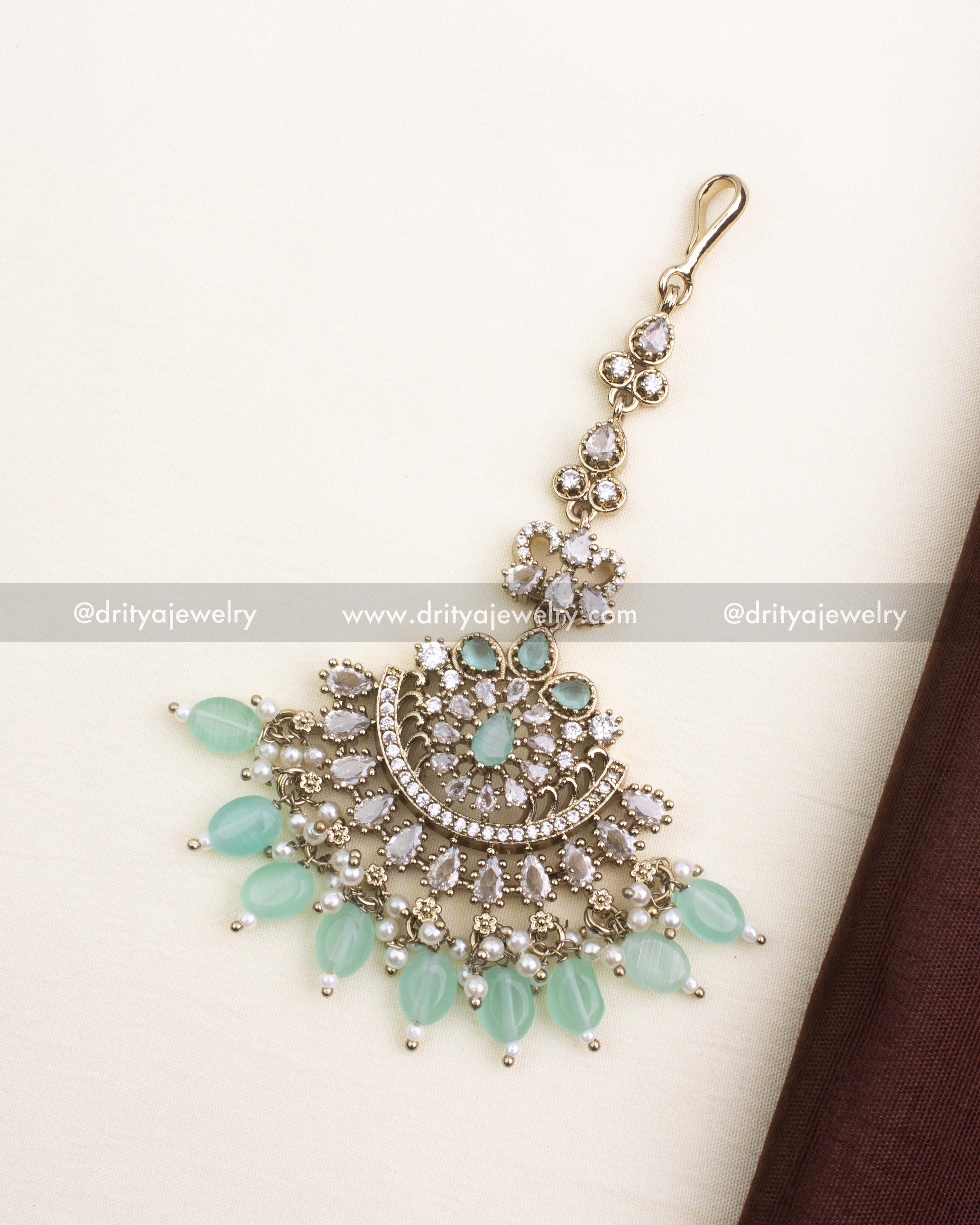 Elegant Victorian-style maang tikka with mint green stones, CZ detailing, and pearls.