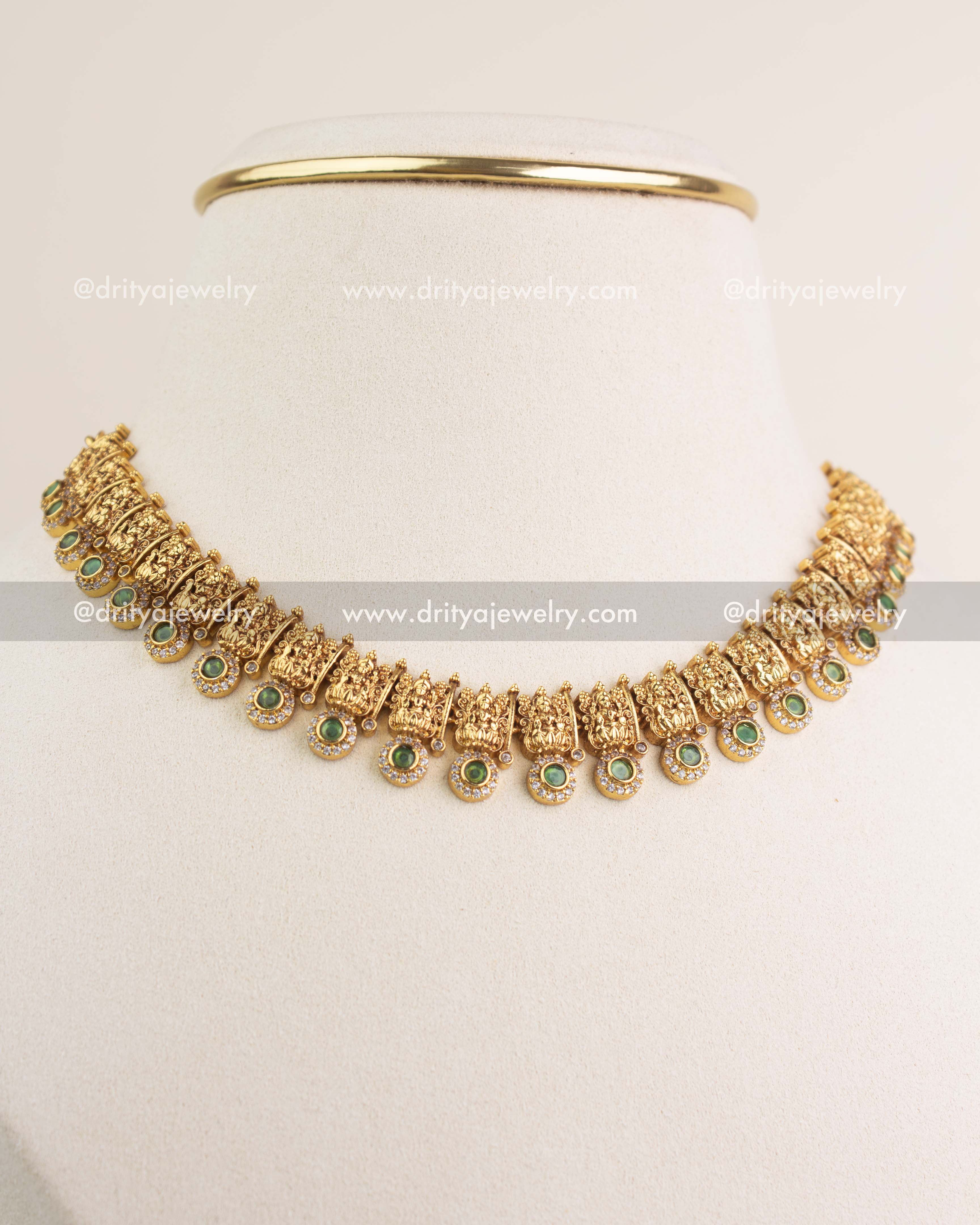 Side-angle view of temple short necklace with green stones