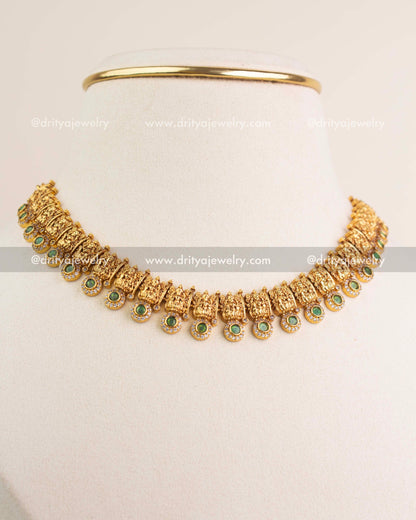 Side-angle view of temple short necklace with green stones