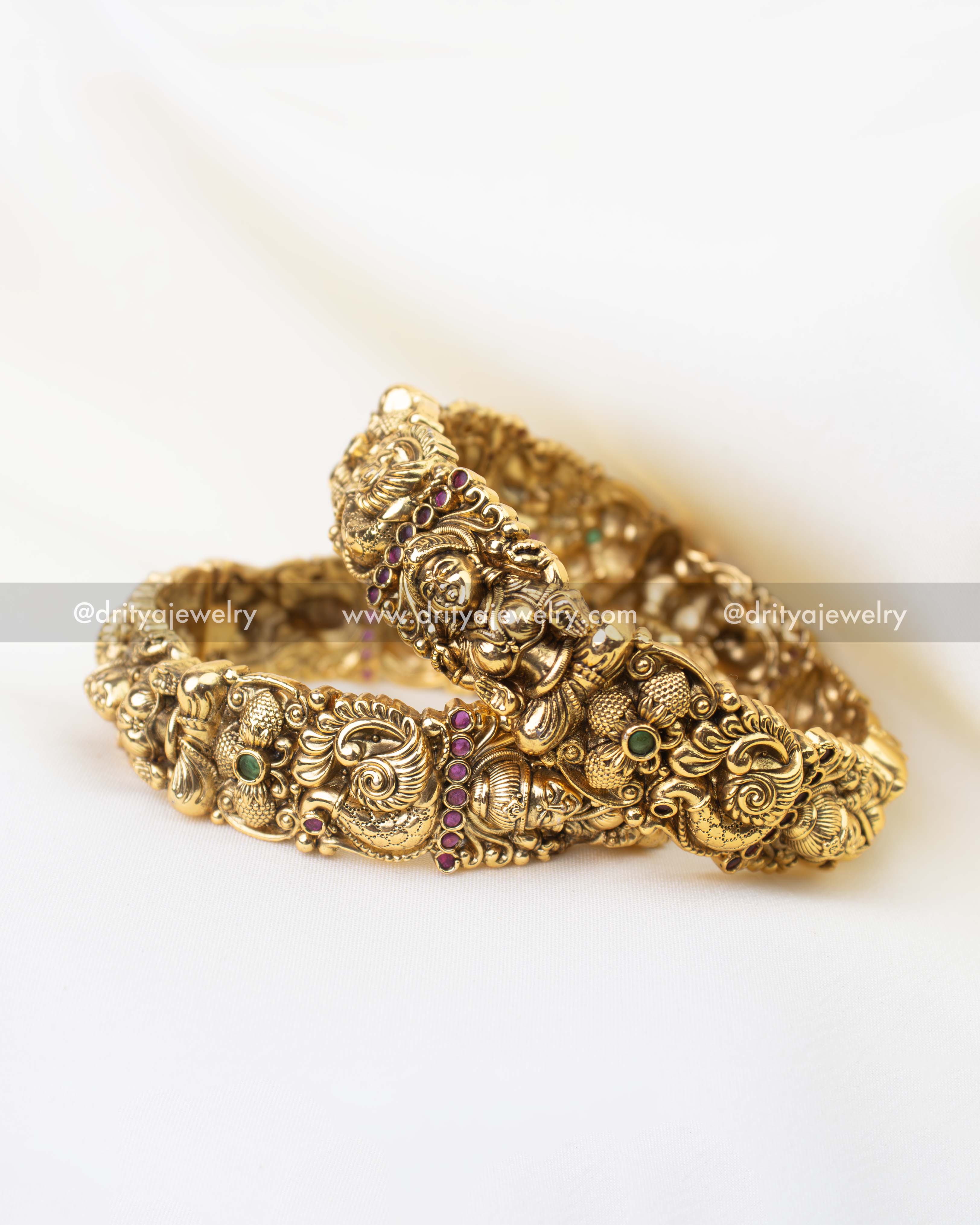 Traditional South Indian bridal kada bangles with peacock motifs and ruby green stone accents