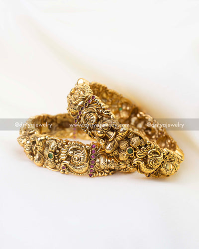 Traditional South Indian bridal kada bangles with peacock motifs and ruby green stone accents