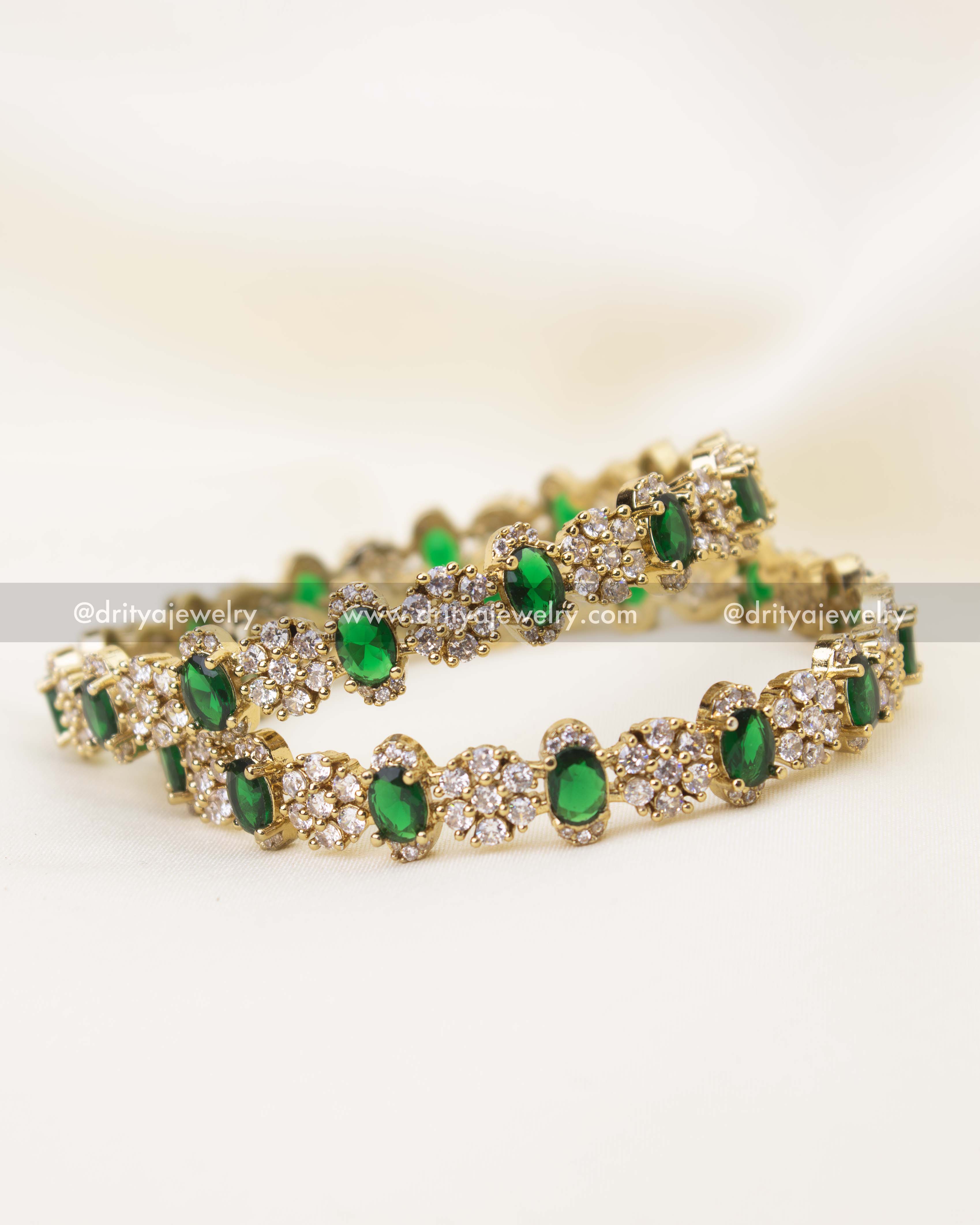 Close-up of emerald green stone Victorian polish bangles with intricate CZ cluster setting