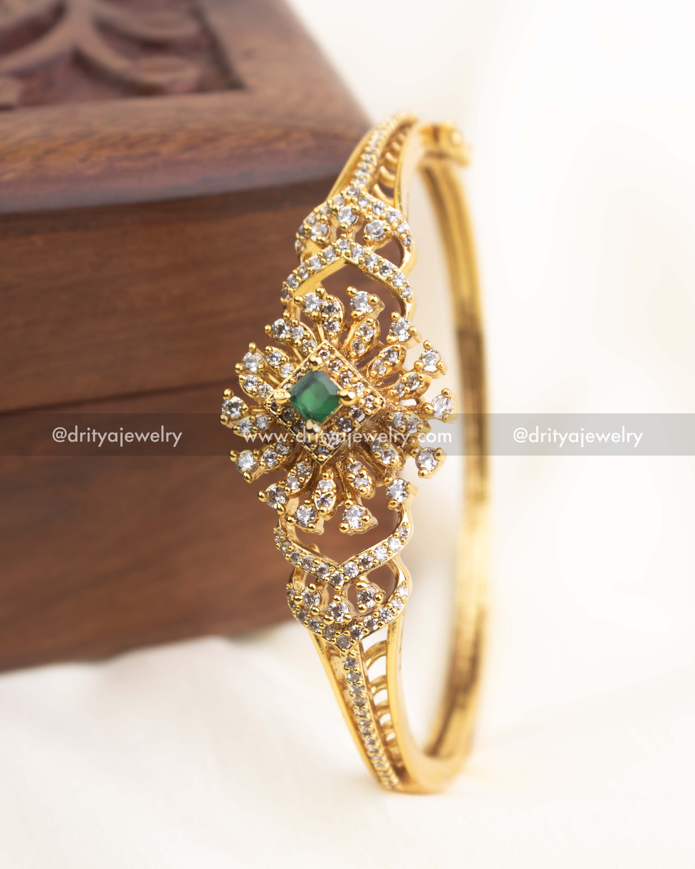 Premium gold-plated openable CZ kada with emerald green stone centerpiece and crystal embellishments.