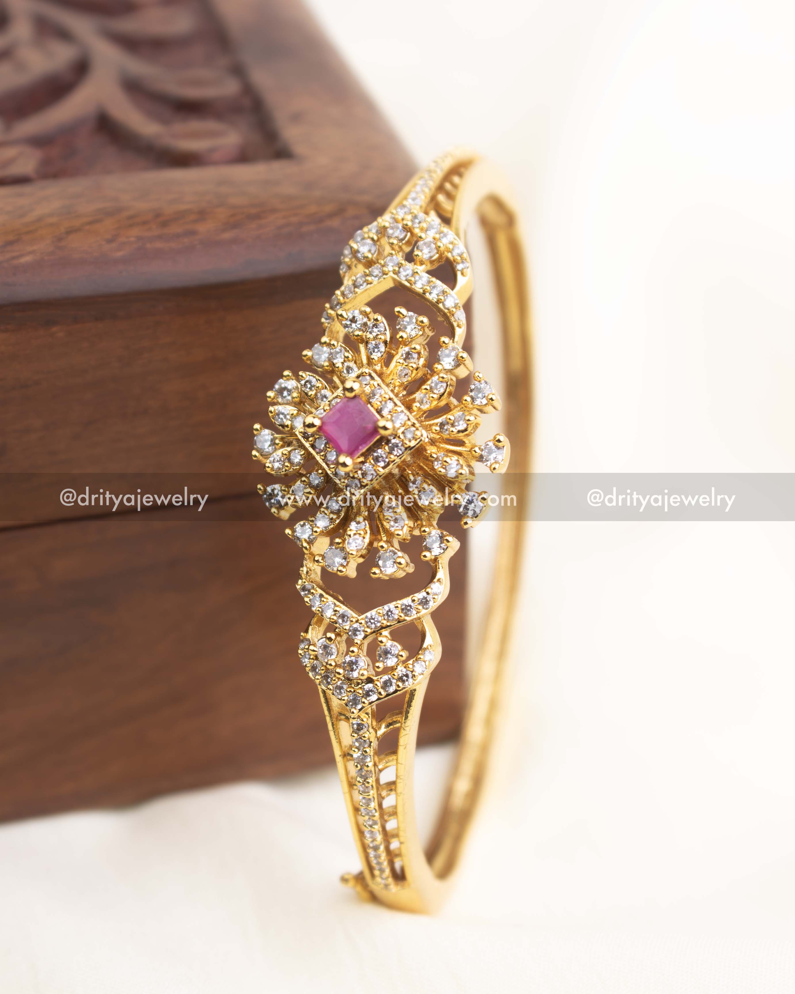 Gold-plated CZ kada with ruby pink stone centerpiece and sparkling floral crystal design.