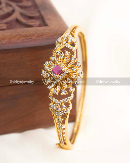 Gold-plated CZ kada with ruby pink stone centerpiece and sparkling floral crystal design.