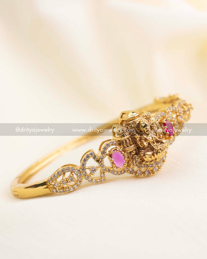 Antique gold Lakshmi temple kada with ruby red CZ stones and intricate CZ-studded side design.