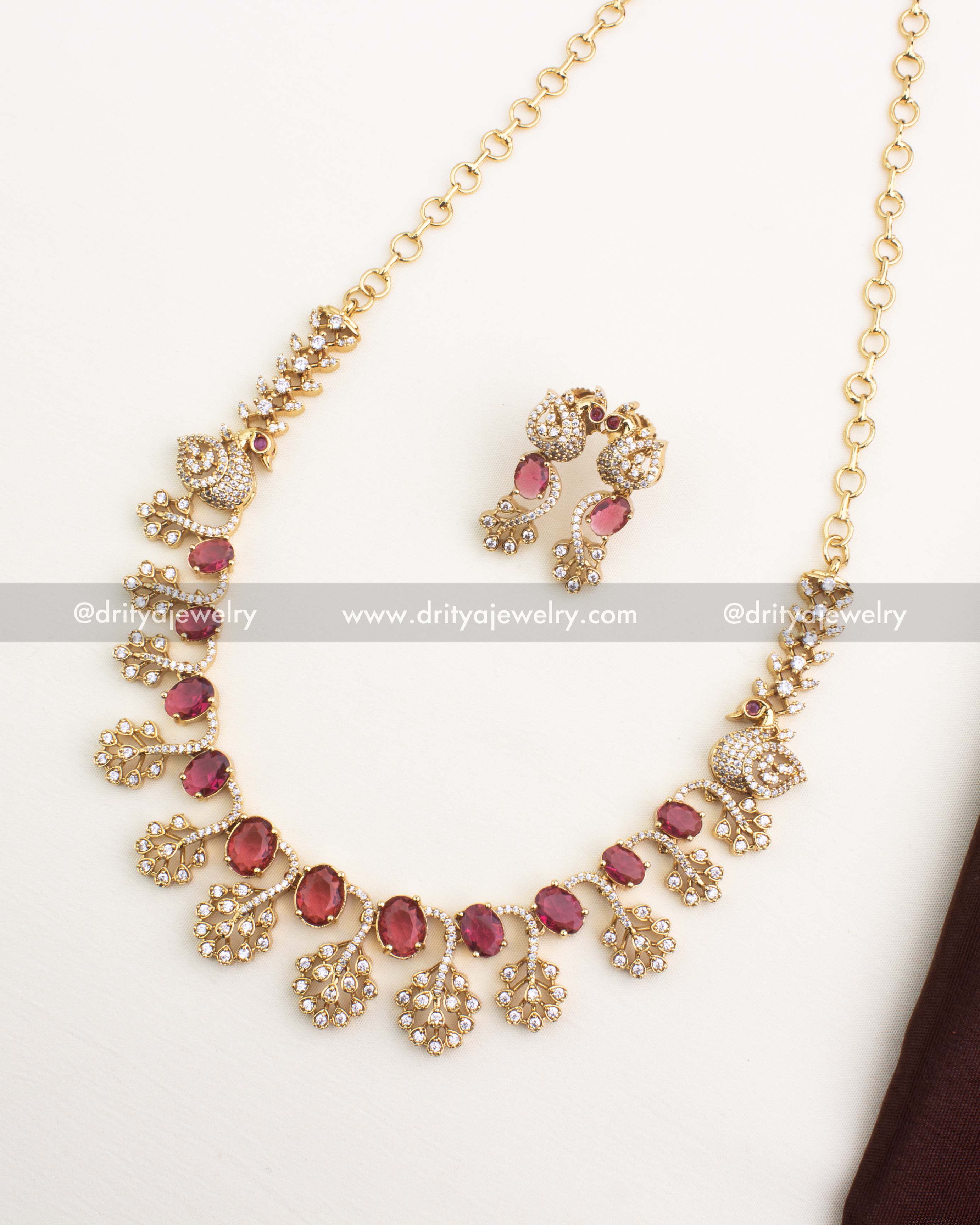 Ruby red CZ short necklace set with peacock design and AD detailing in gold polish.