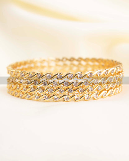 Gold-polish slim bangles with wave-pattern CZ stones arranged in a diamond-alike style.