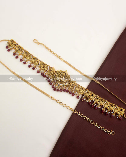Premium temple hip chain with ruby red bead hangings, peacock motifs, and Lakshmi pendant.