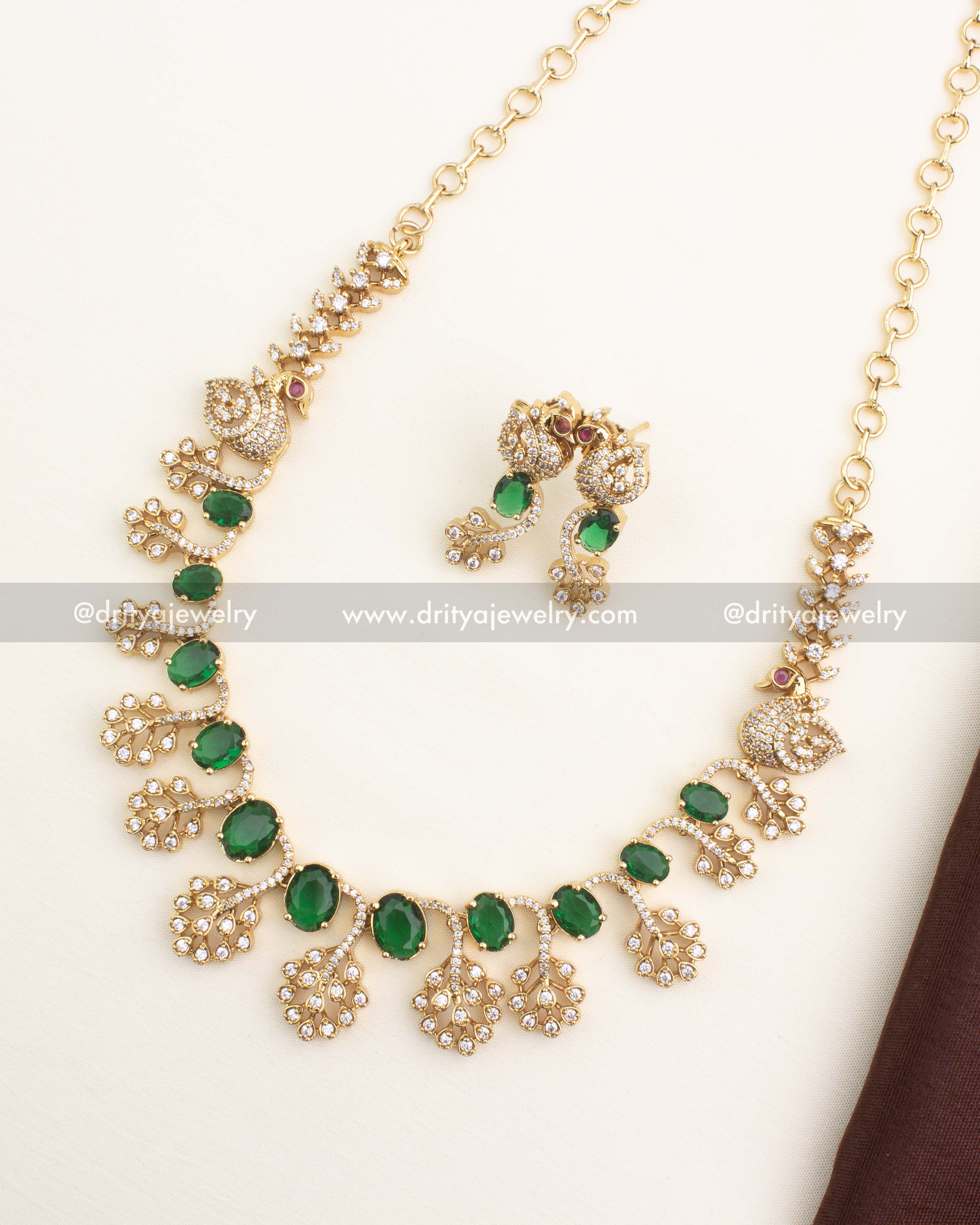 Gold-plated short necklace set with emerald green CZ stones and peacock motif design by Dritya Jewelry.