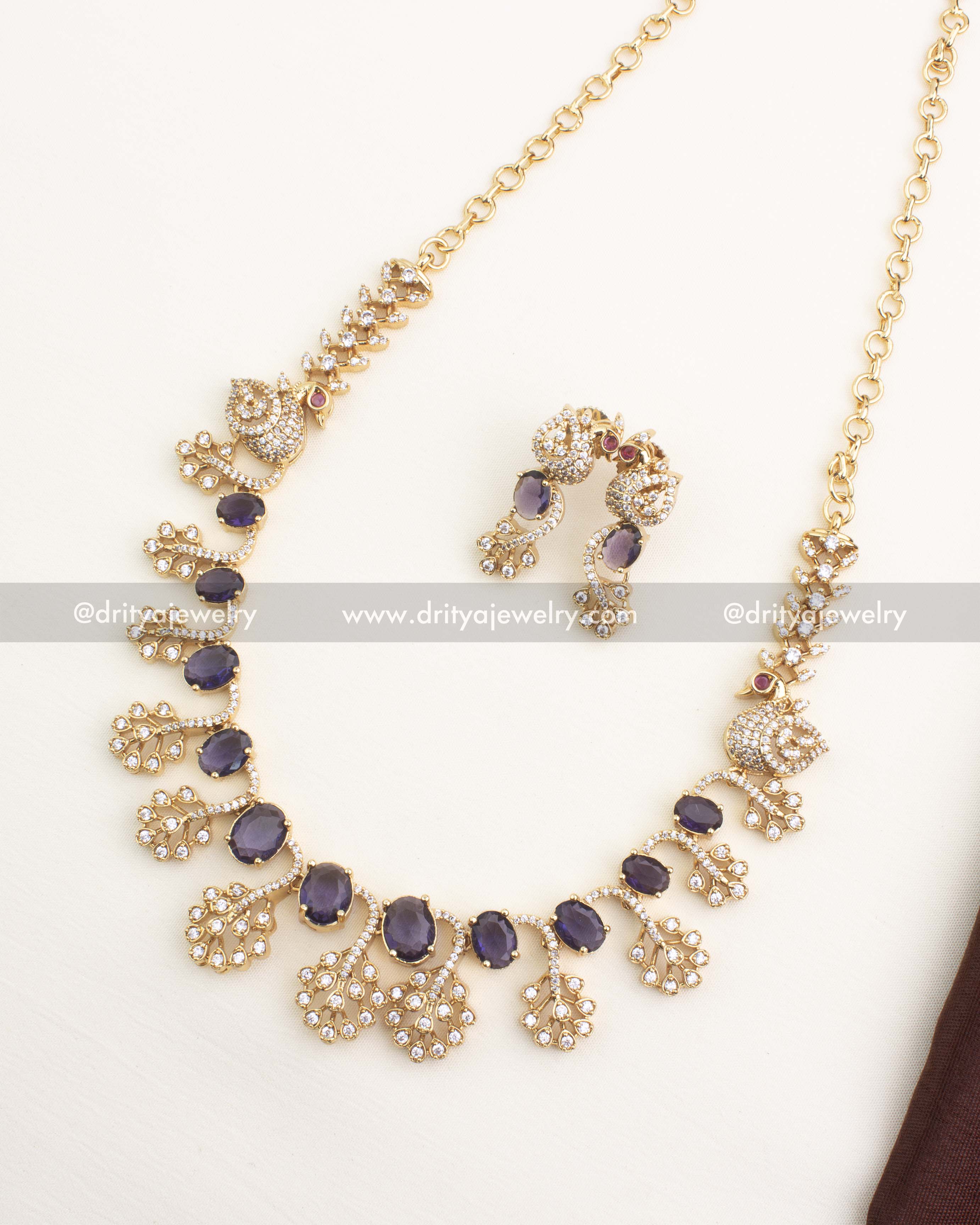 Short necklace set with purple CZ stones and peacock-inspired motifs in gold polish.