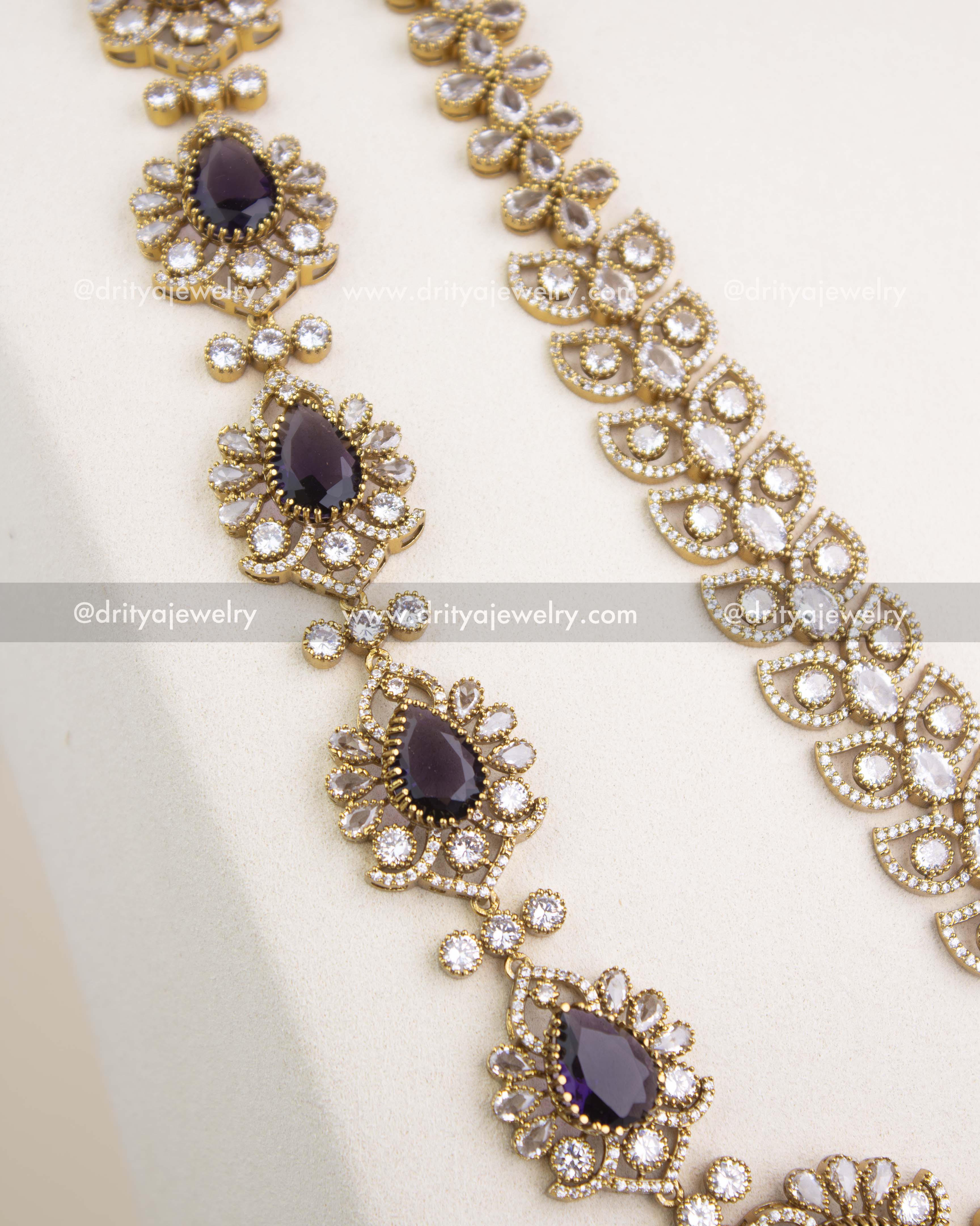 Close-up of Victorian chain pattern with teardrop CZ stones and intricate floral detailing in antique gold.