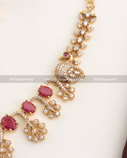 Close view of ruby stones set with shimmering CZ branches and peacock accents.