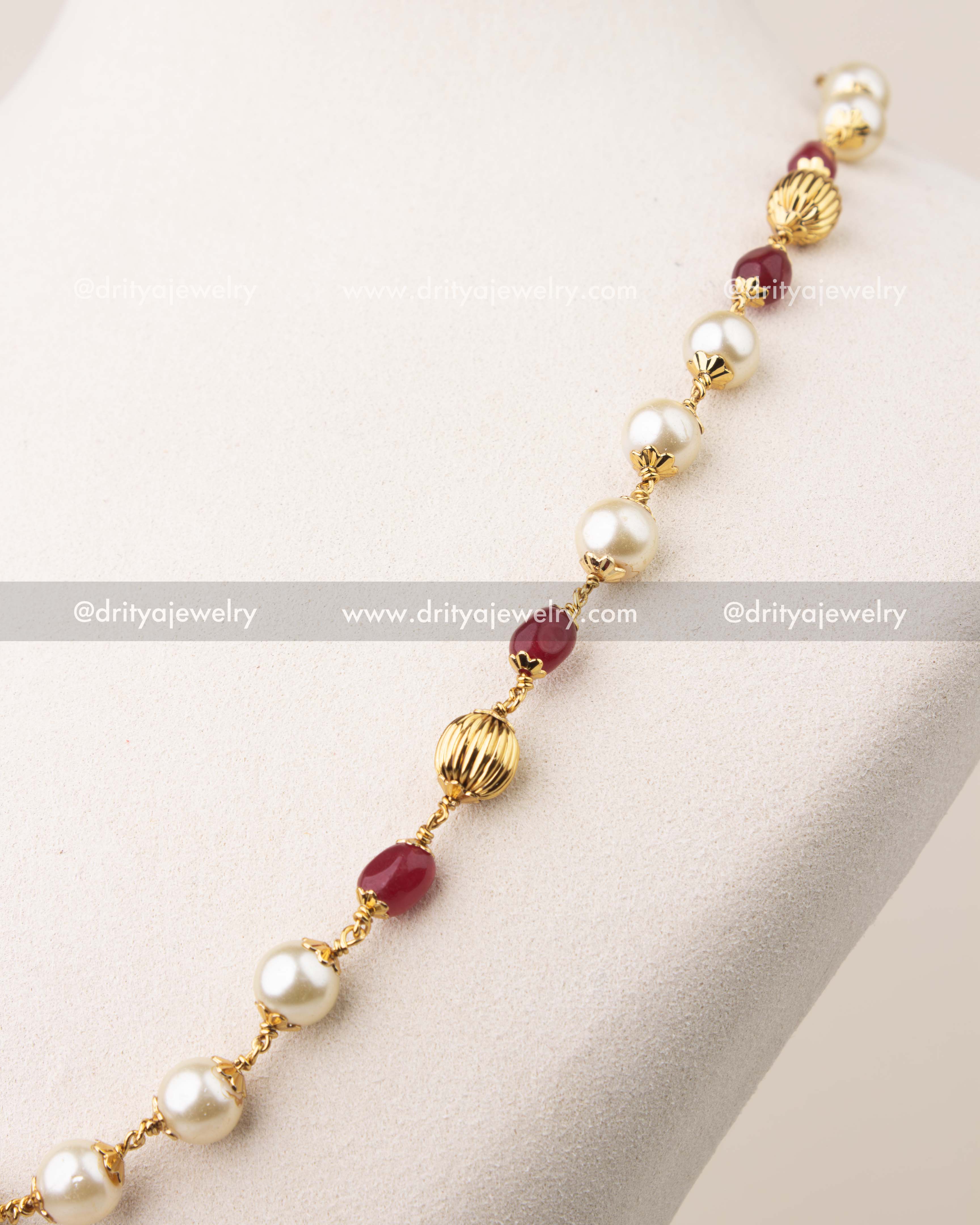 Side view of pearl and ruby beads mala necklace with gold polish finish