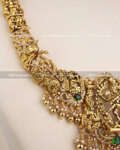 Intricate Nakshi chain design with miniature figurines, carvings, and green stone accents.