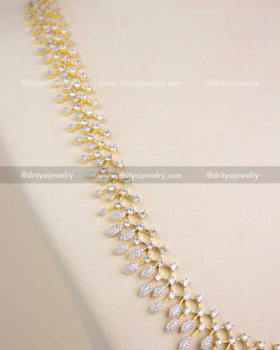 Close-up of CZ-studded leaf design in GJ polish long necklace.