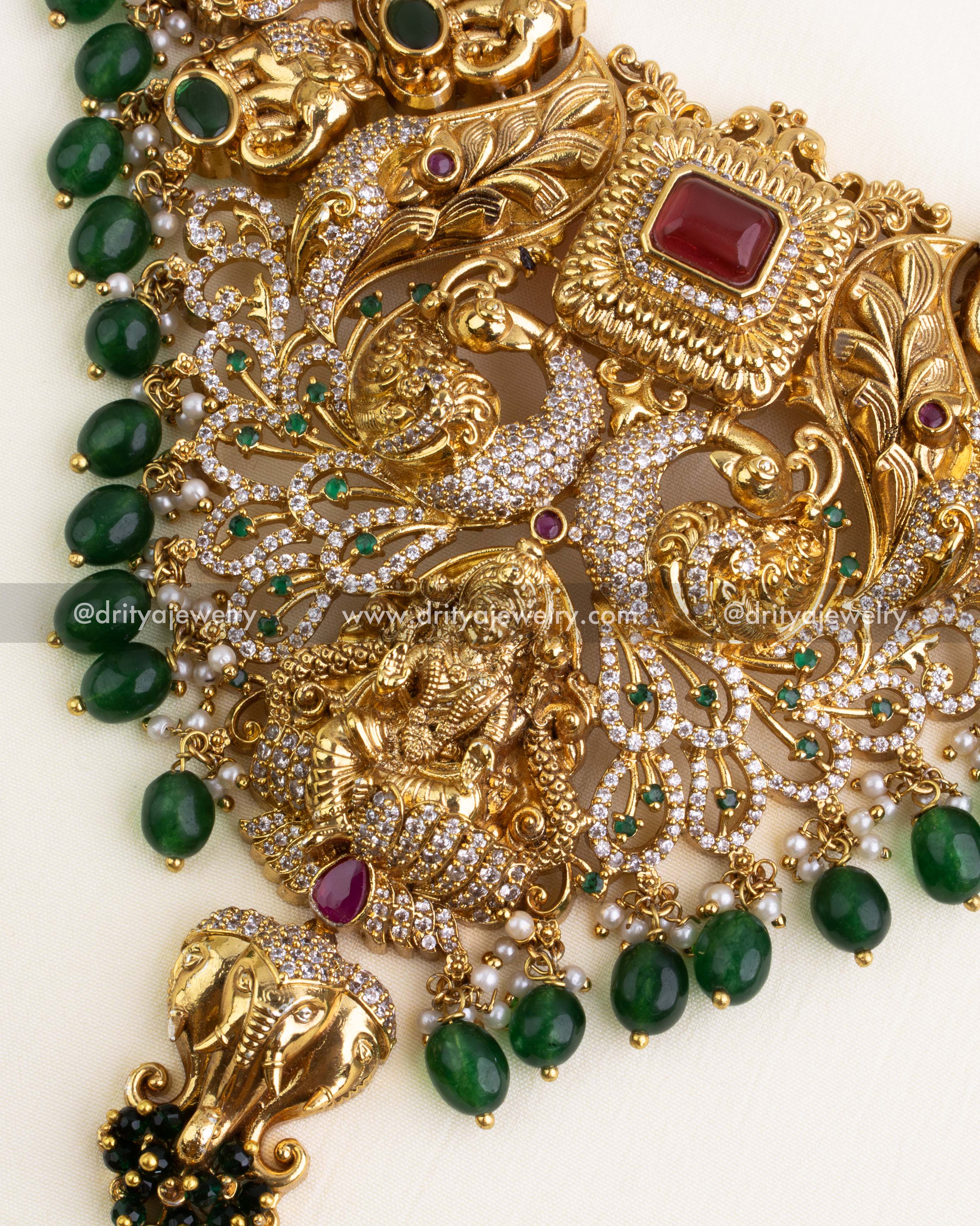 Zoom-in of Goddess Lakshmi Devi idol, peacocks, and green bead lining.