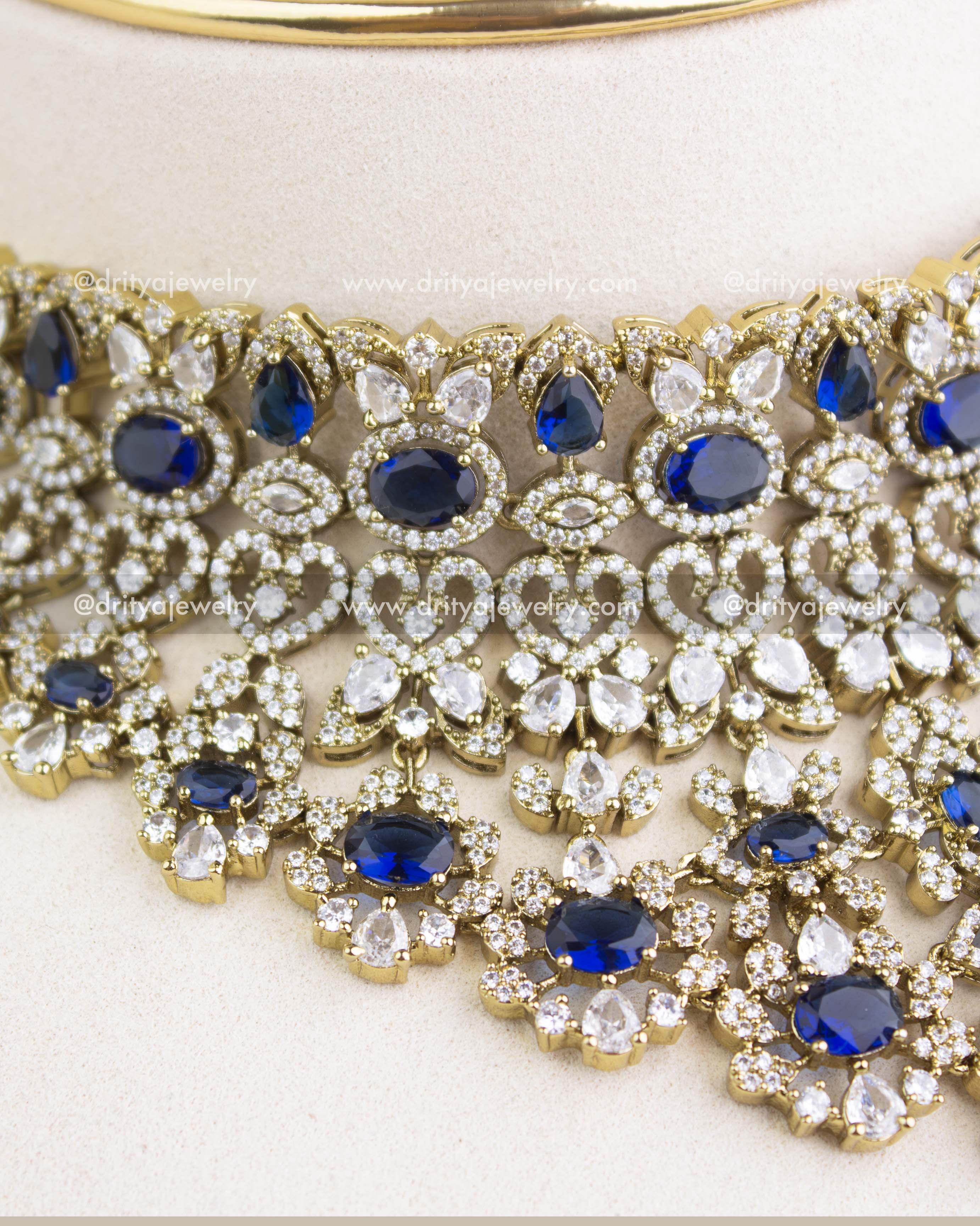 Close-up image of sapphire blue Victorian choker showcasing floral clusters, teardrop stones, and micro AD setting.
