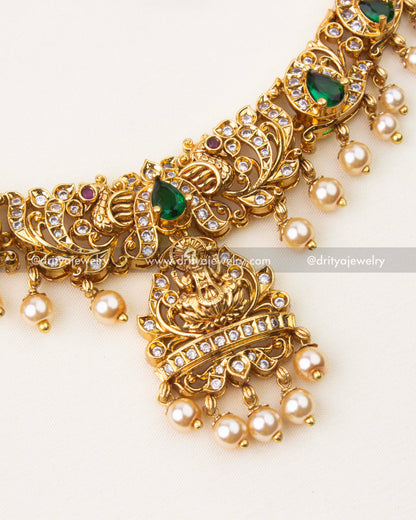 Close-up of Nakshi temple necklace featuring emerald green stones, CZ accents and pearl hangings