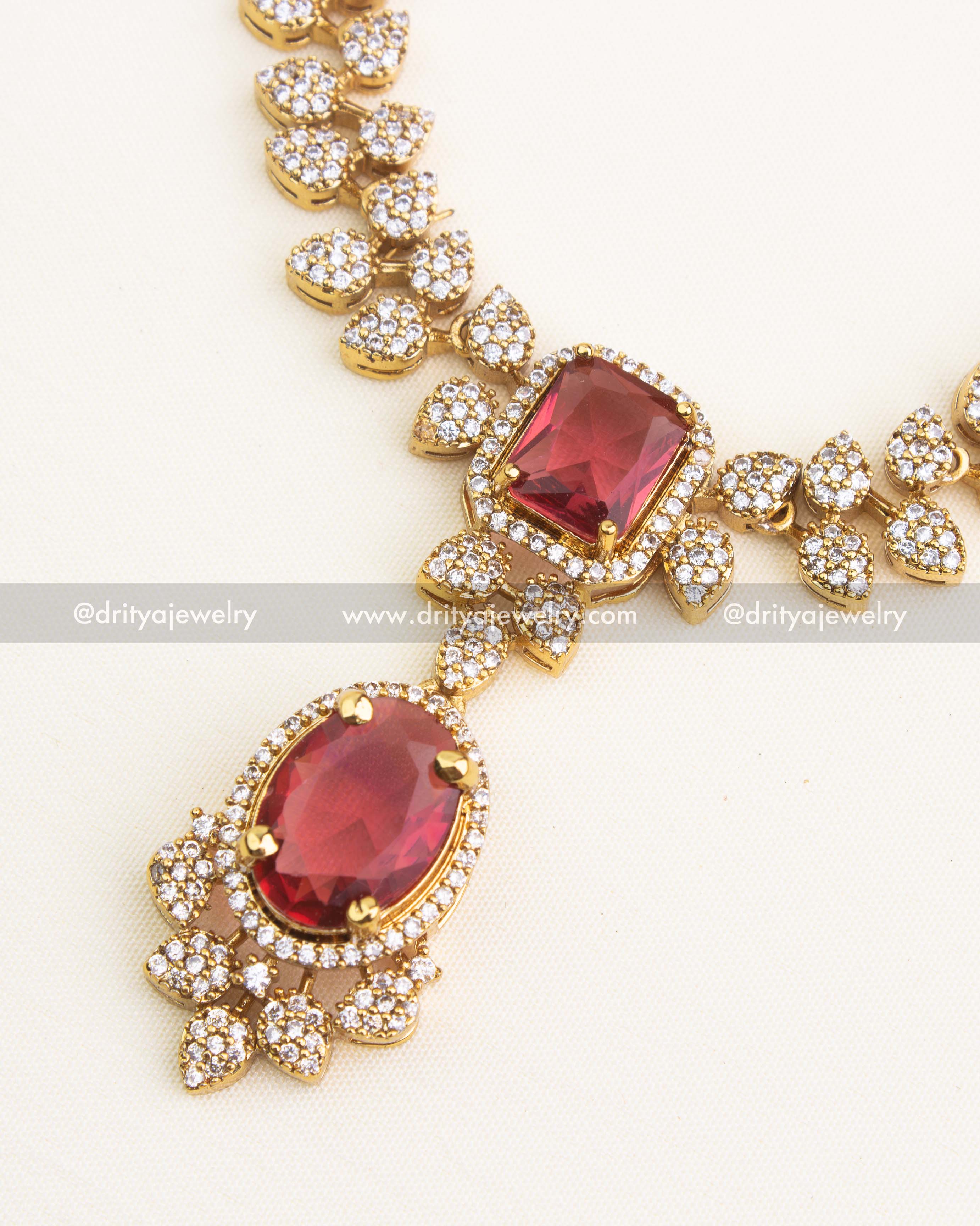 Close-up of red oval pendant and cushion-cut centerpiece.