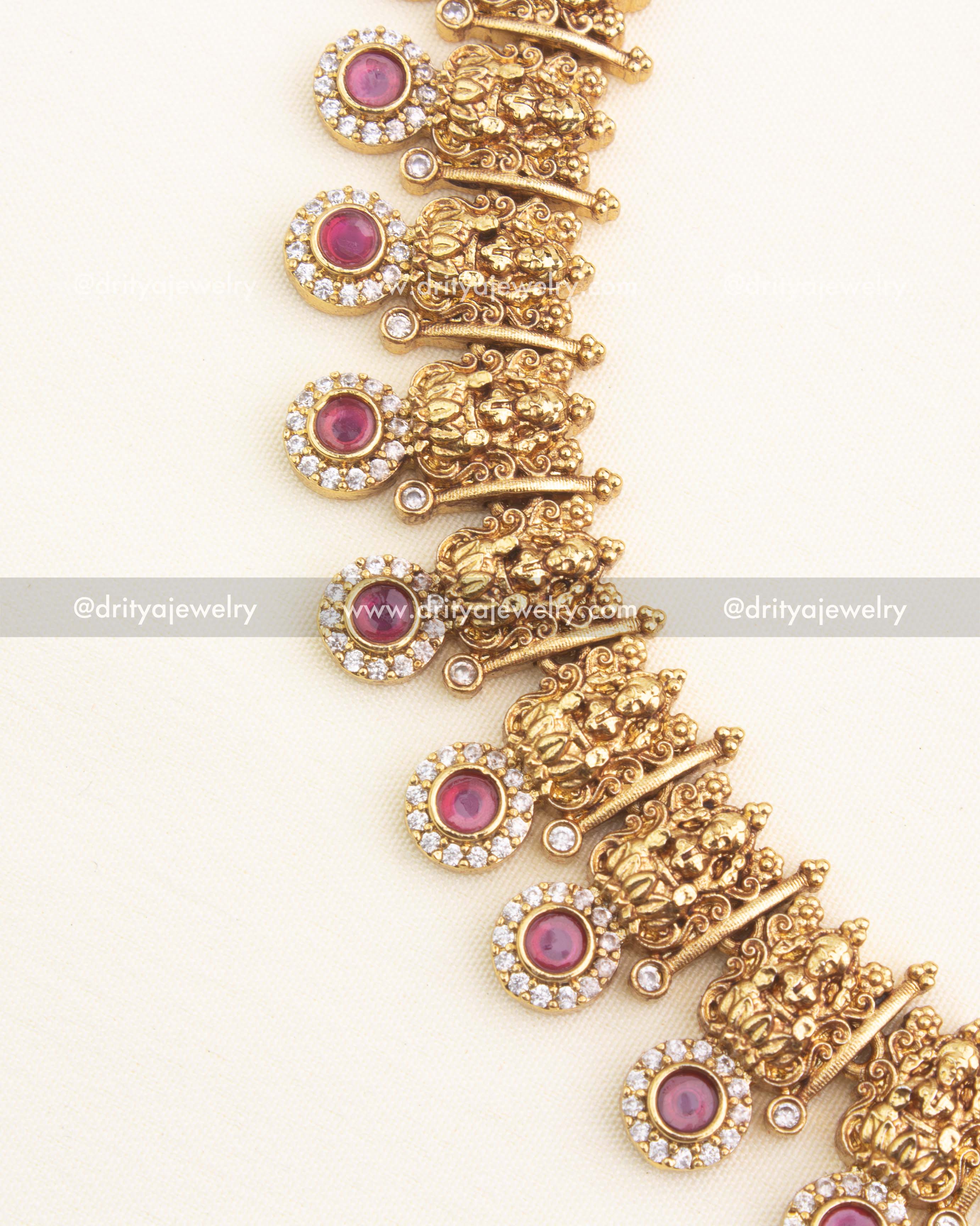 Close-up of Lakshmi motifs with red stone detailing on temple choker necklace