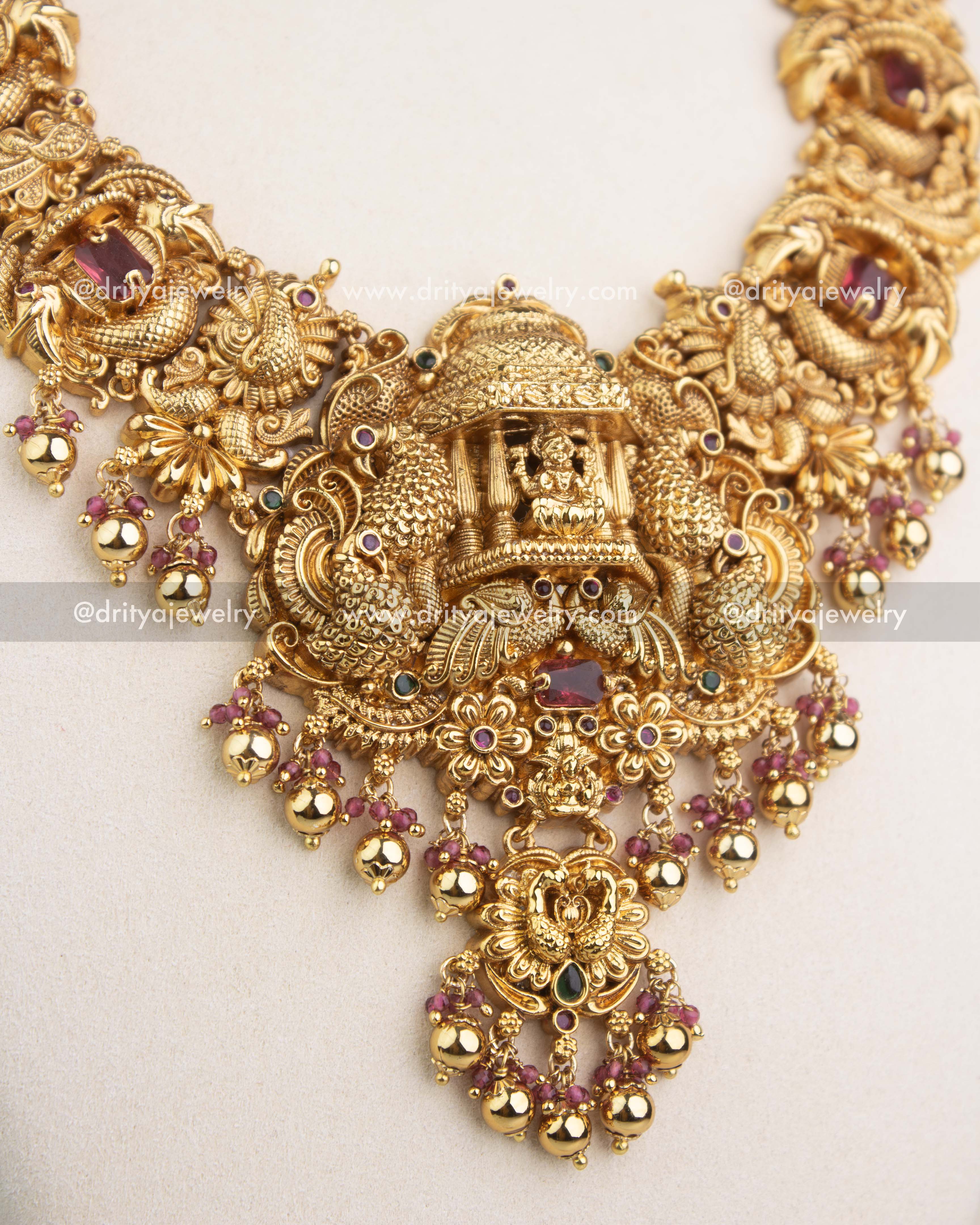 Highly detailed temple pendant with goddess carving, peacocks, and ruby red accents.