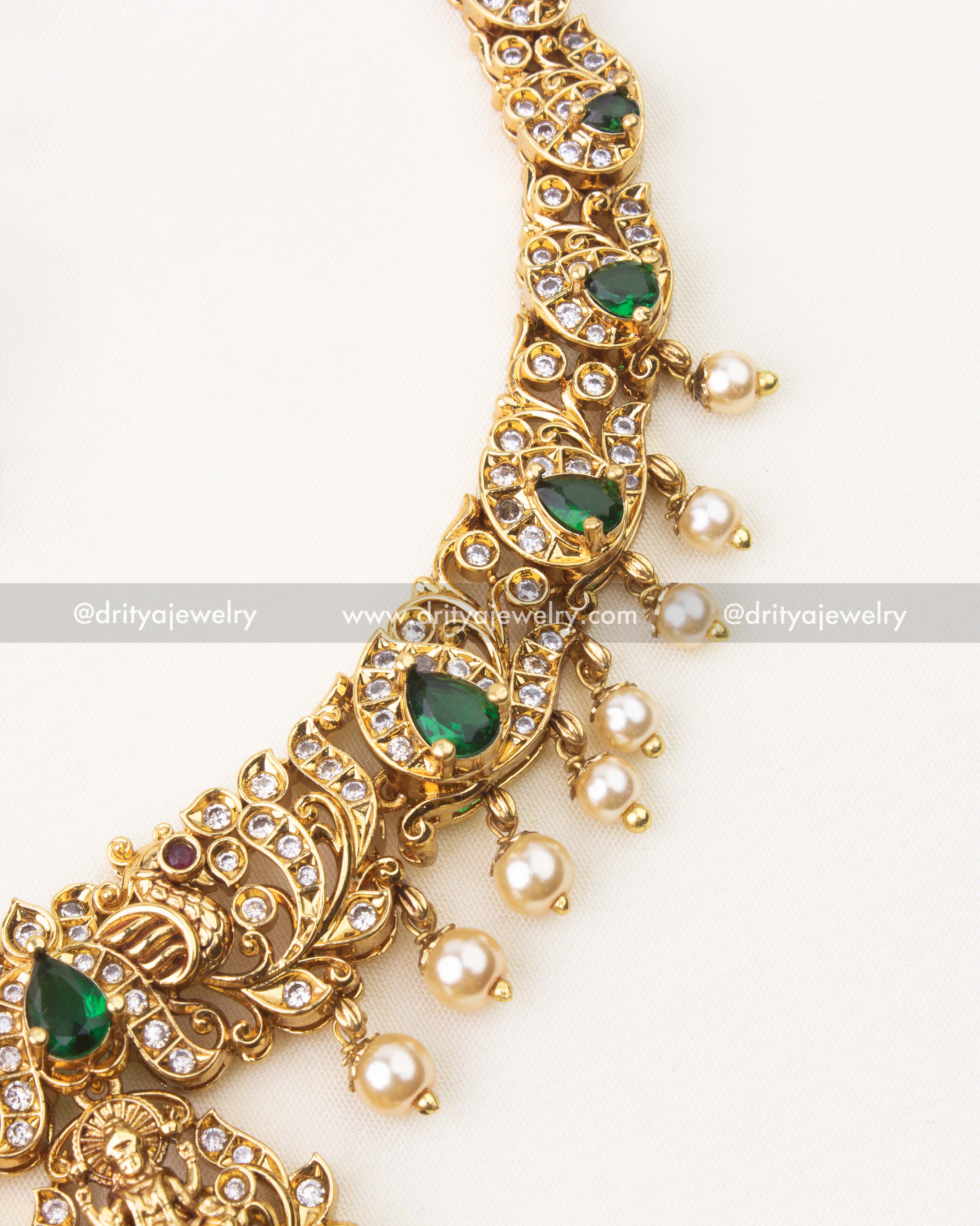 Close-up of Nakshi temple necklace featuring emerald green stones, CZ accents and pearl hangings