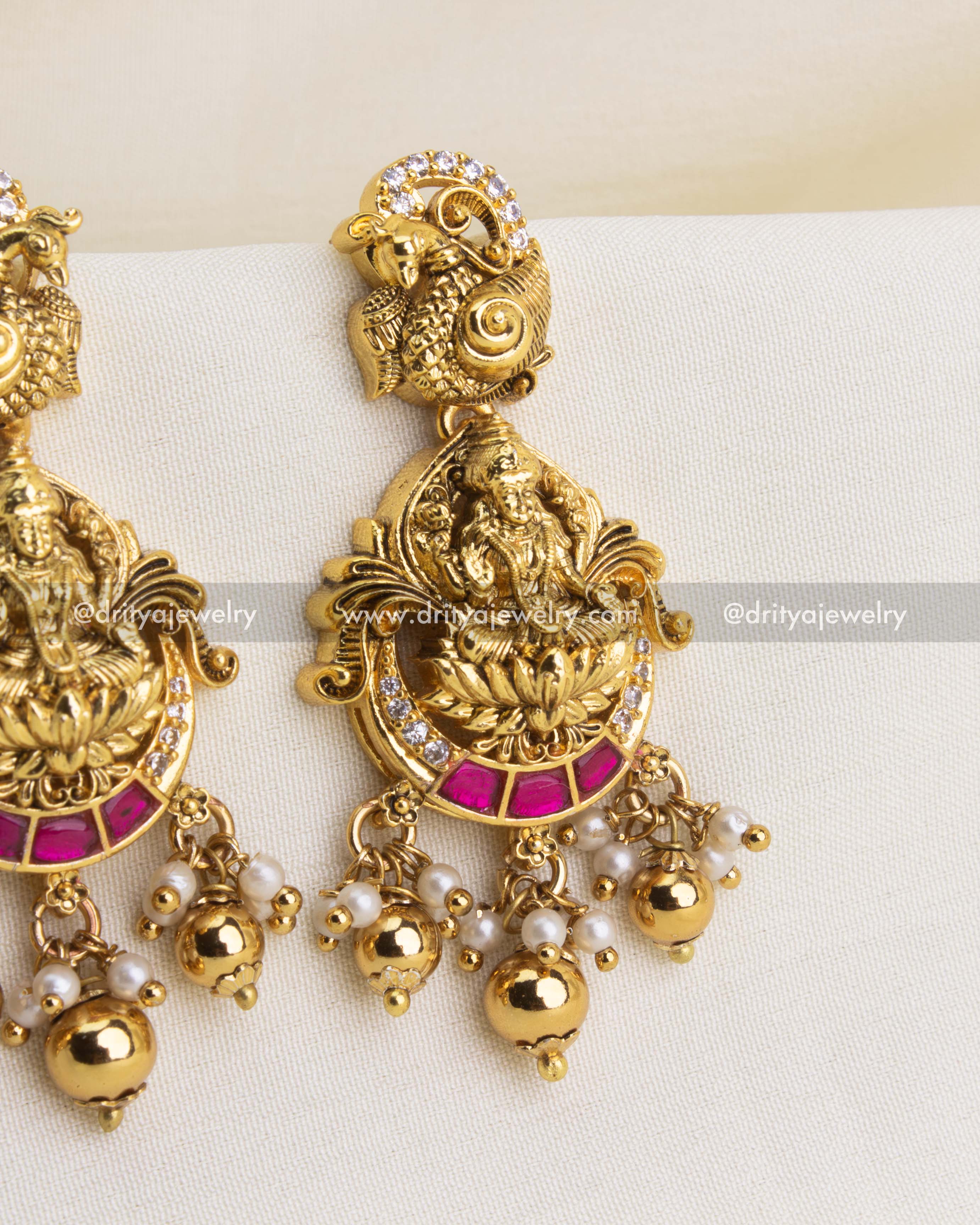 Close-up of Lakshmi motif with ruby red stones and pearl drops