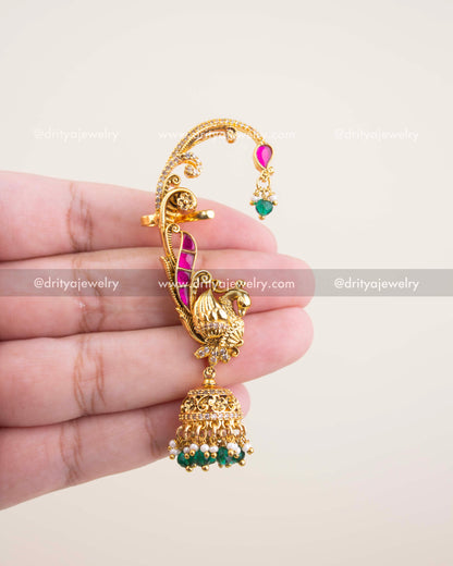 Close-up showing pink kemp stones, peacock carving, and jhumka pearl-bead cluster