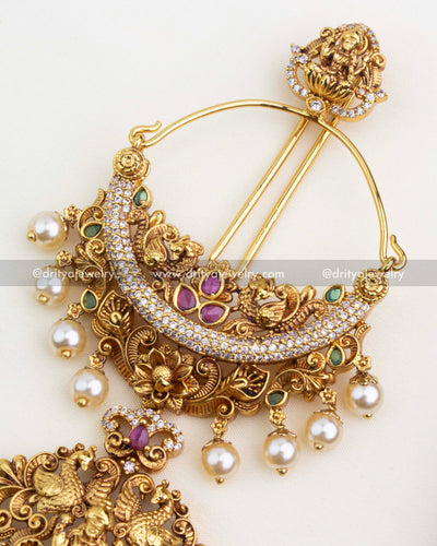 Close-up of the top floral and temple-inspired detailing with pearl drops.