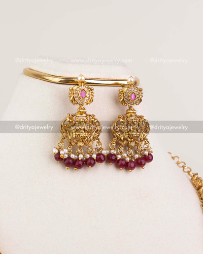 1240-R temple jhumka earrings with ruby bead drops displayed with matching bangle